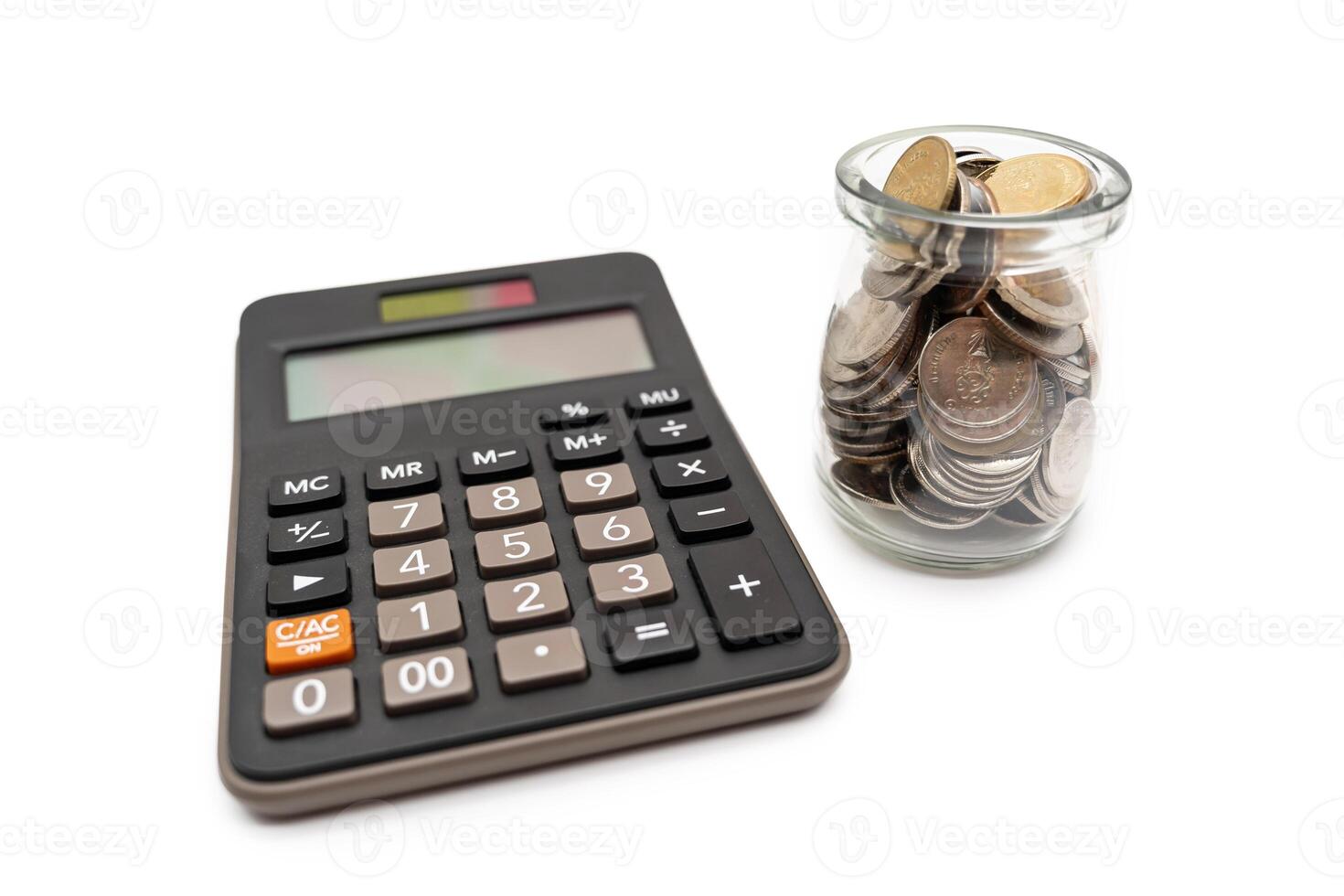 Coins in glass money jar with calculator, financial concept. isolated on white background. photo