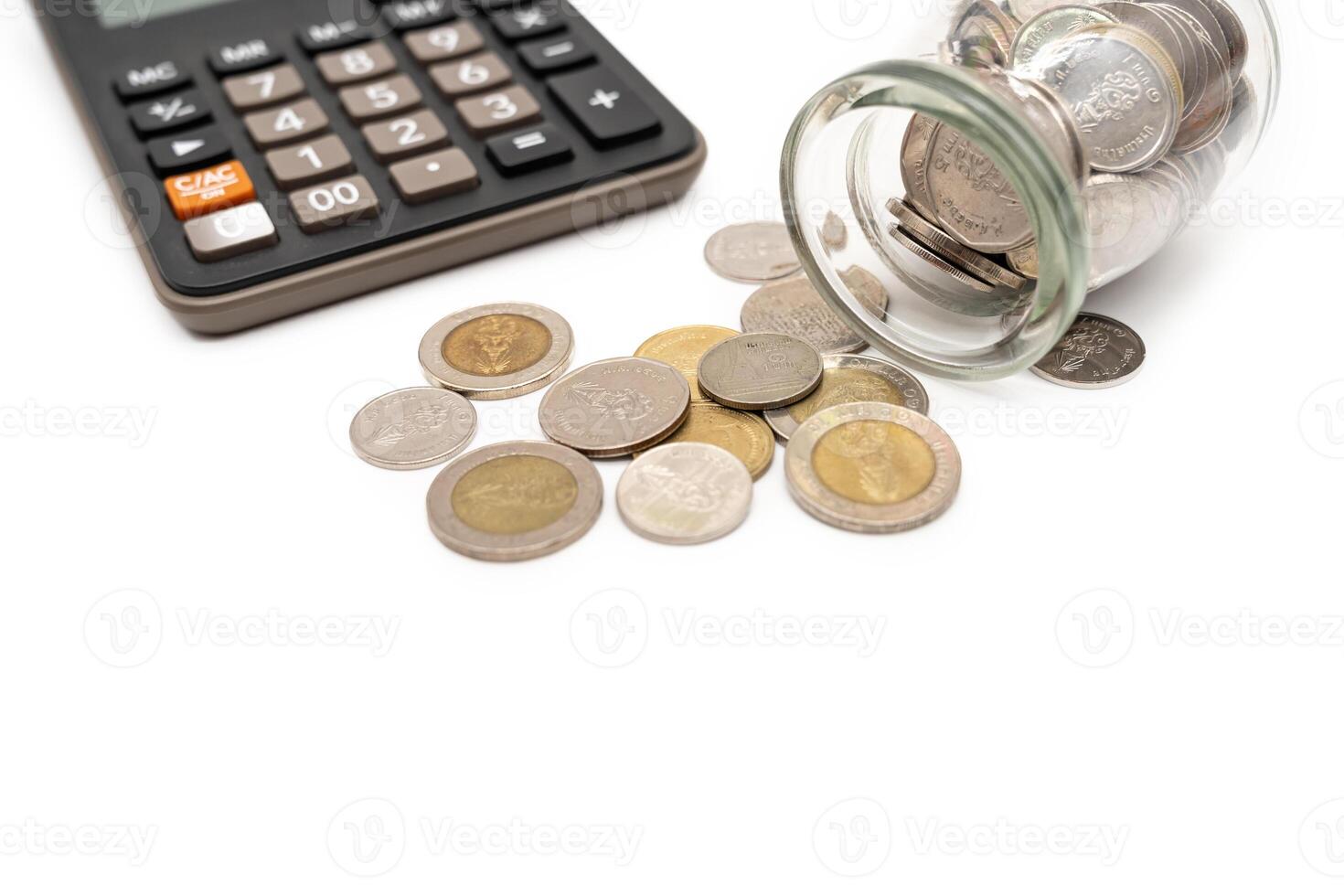 Thai Baht Coins spilled out of jar glass and Calculator isolated on white background, saving for future, Investment business concept. Business and Financial Concept. Copy space. photo