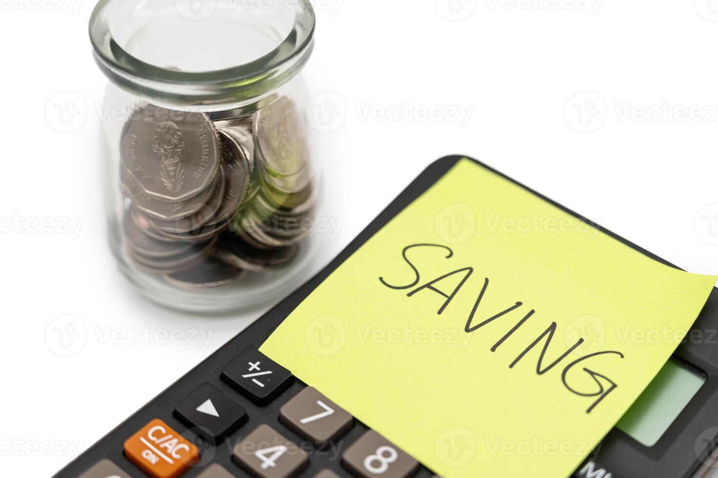 SAVING text with sticky note on calculator and Coins in glass money jar isolated on white background, financial concept. photo