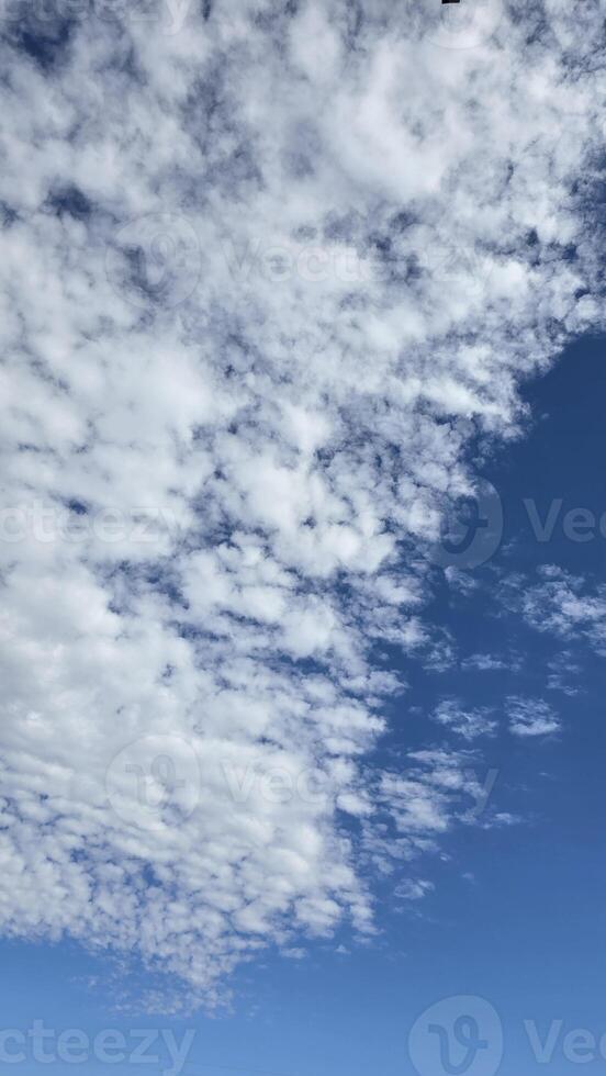 Bright and serene blue sky scattered with fluffy white clouds, depicting the beauty of tranquility. Perfect background for concepts such as freedom, nature, photo