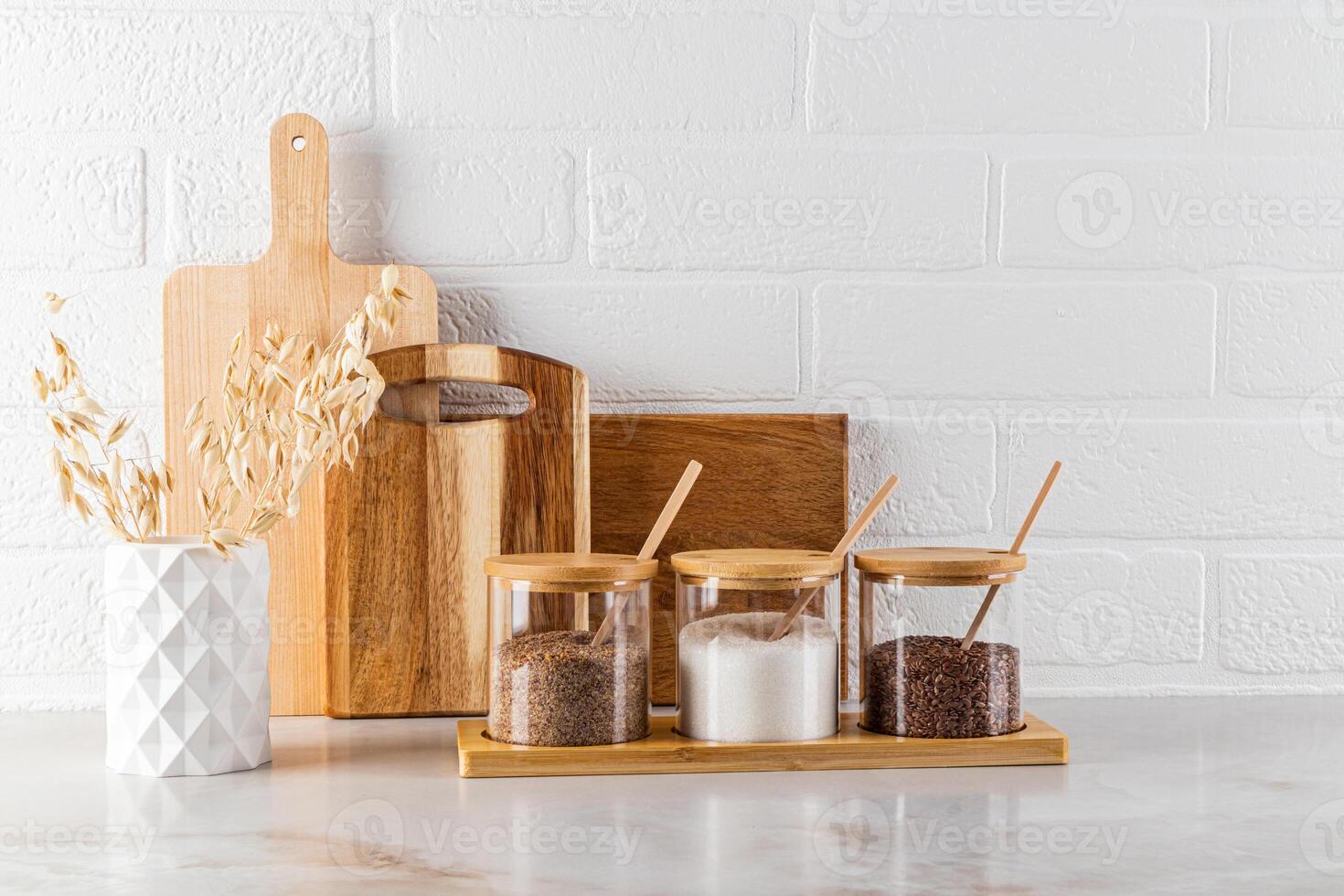 A modern kitchen space in the interior of a kitchen with a set of jars for storing spices, boards, a vase of ears of wheat. Eco-friendly kitchen. photo