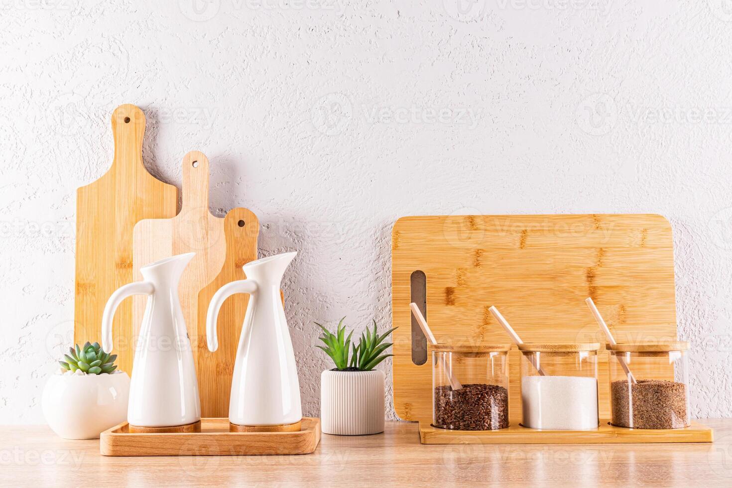 A storage area for spices in glass jars, oils in ceramic special bottles on a wooden countertop in the kitchen. Front view. Zero waste house concept photo