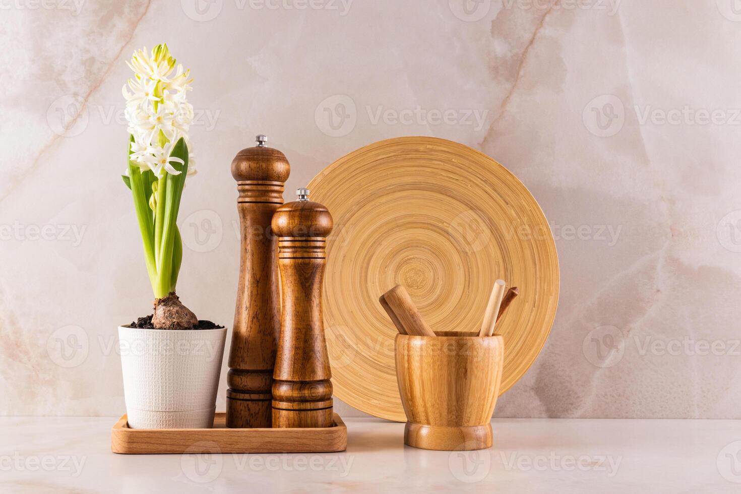 A beautiful minimalist kitchen background with a set of kitchen utensils and a blooming spring potted flower. Front view. Eco-friendly kitchen. photo