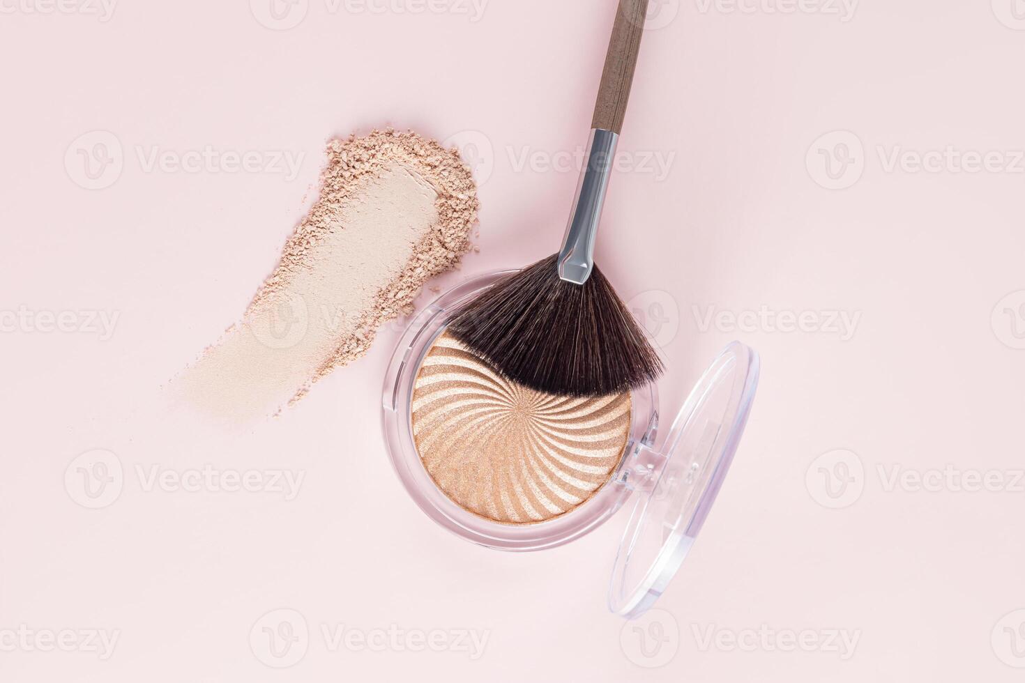 Chic open pack of natural tone glitter highlighter, stroke, texture swatch and fan makeup brush on pastel background. top view. close up. photo