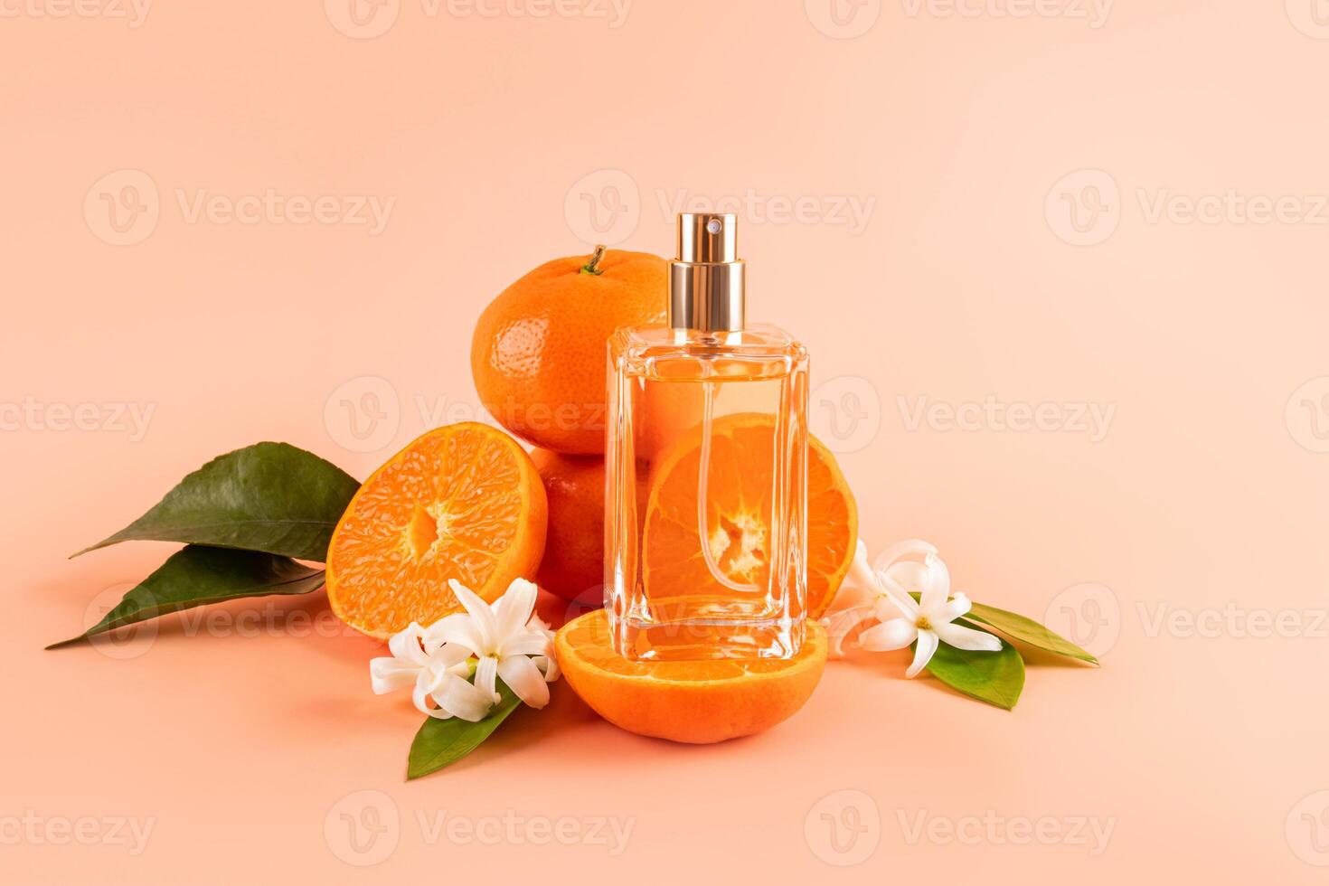A transparent bottle of cosmetics, perfume, cologne stands on a slice of juicy tangerine, ripe fruits with leaves and flowers. A blank bottle mockup photo
