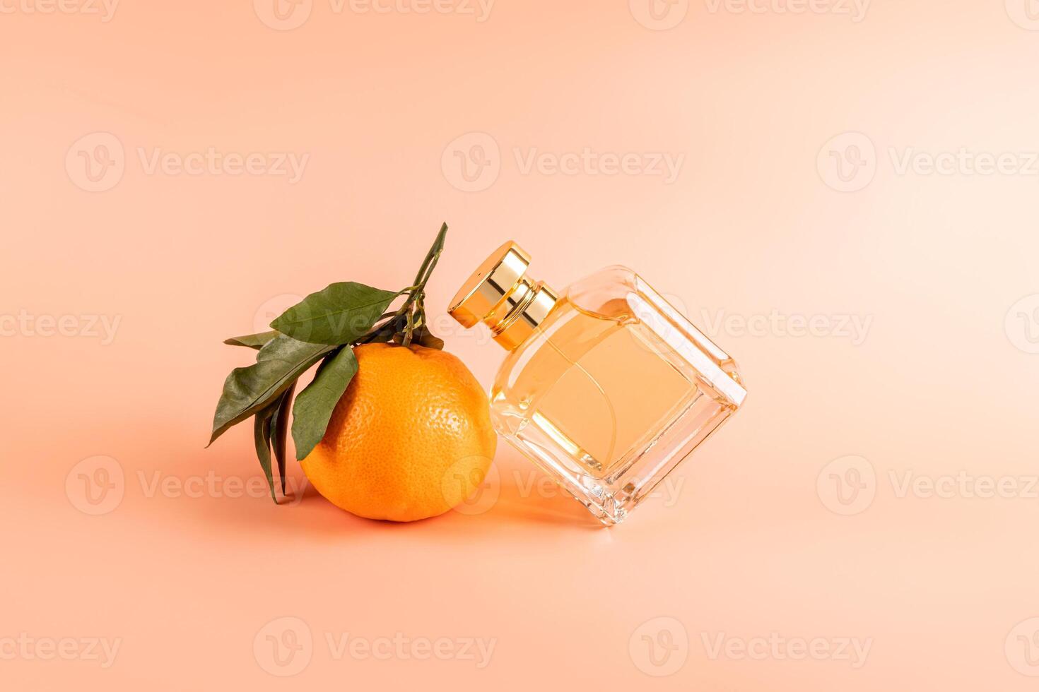 A unbranded bottle of perfume with the smell of citrus notes leaned on a ripe orange tangerine fruit. feminine and masculine essence. Front view photo