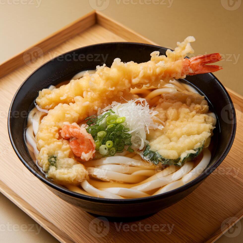 A delicious bowl of Japanese udon noodles topped with tempura shrimp and green onions. photo