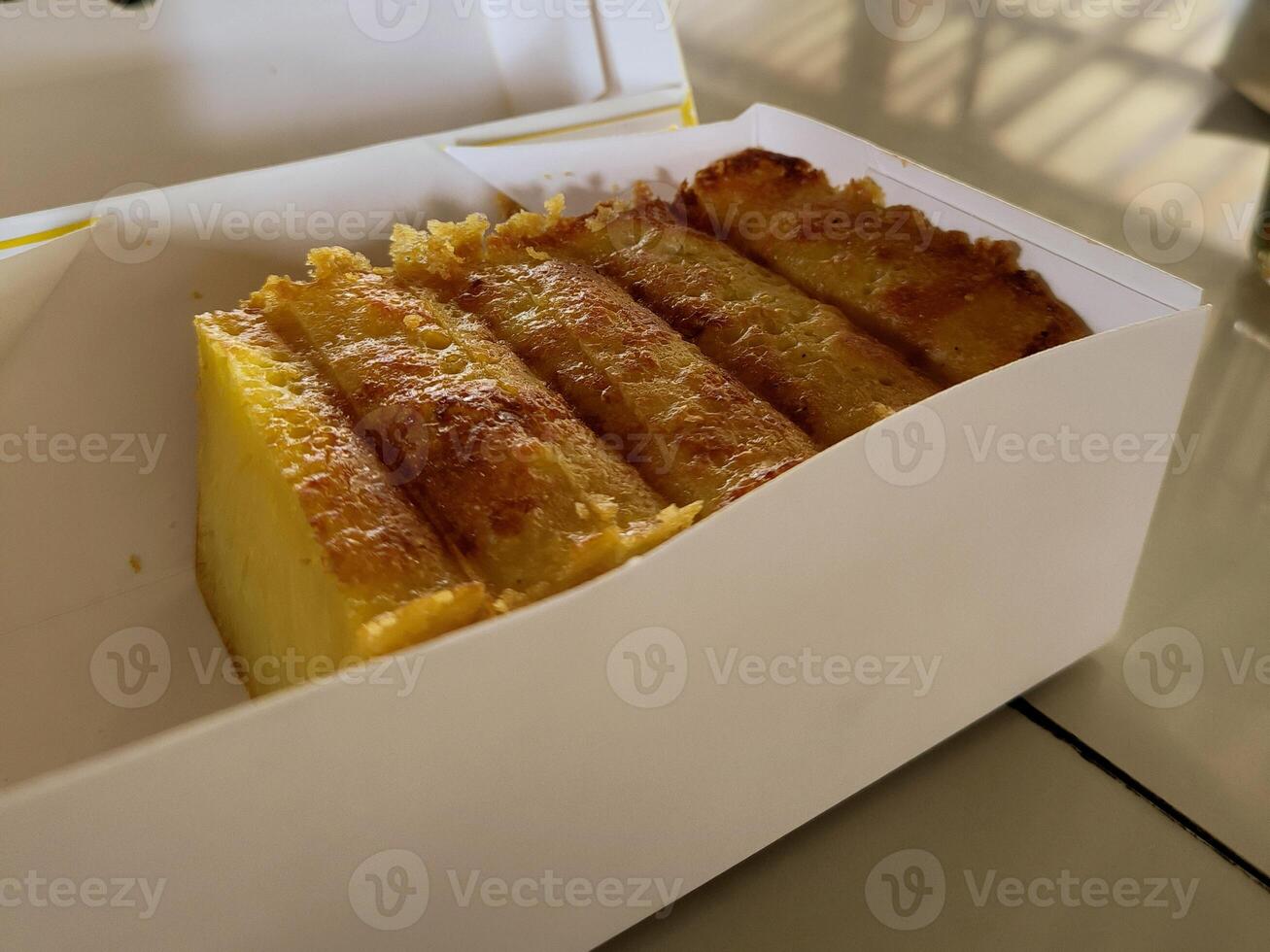 A beautiful and delicious cake made from tapioca flour, sugar, coconut milk and chicken eggs in a paper box. photo