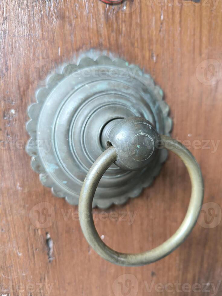 antique door handle pull model on wooden door of old house photo