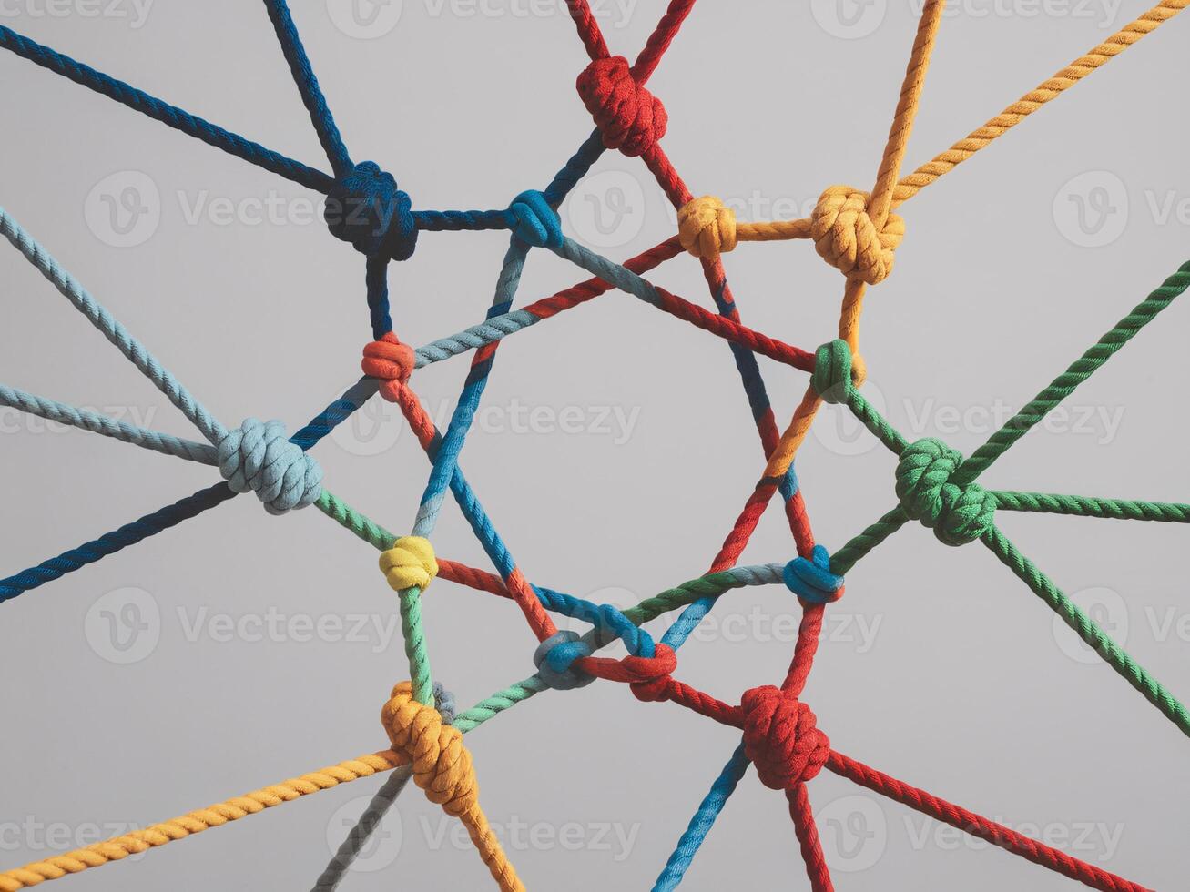 Colorful ropes intertwined in a complex pattern against a gray background. photo