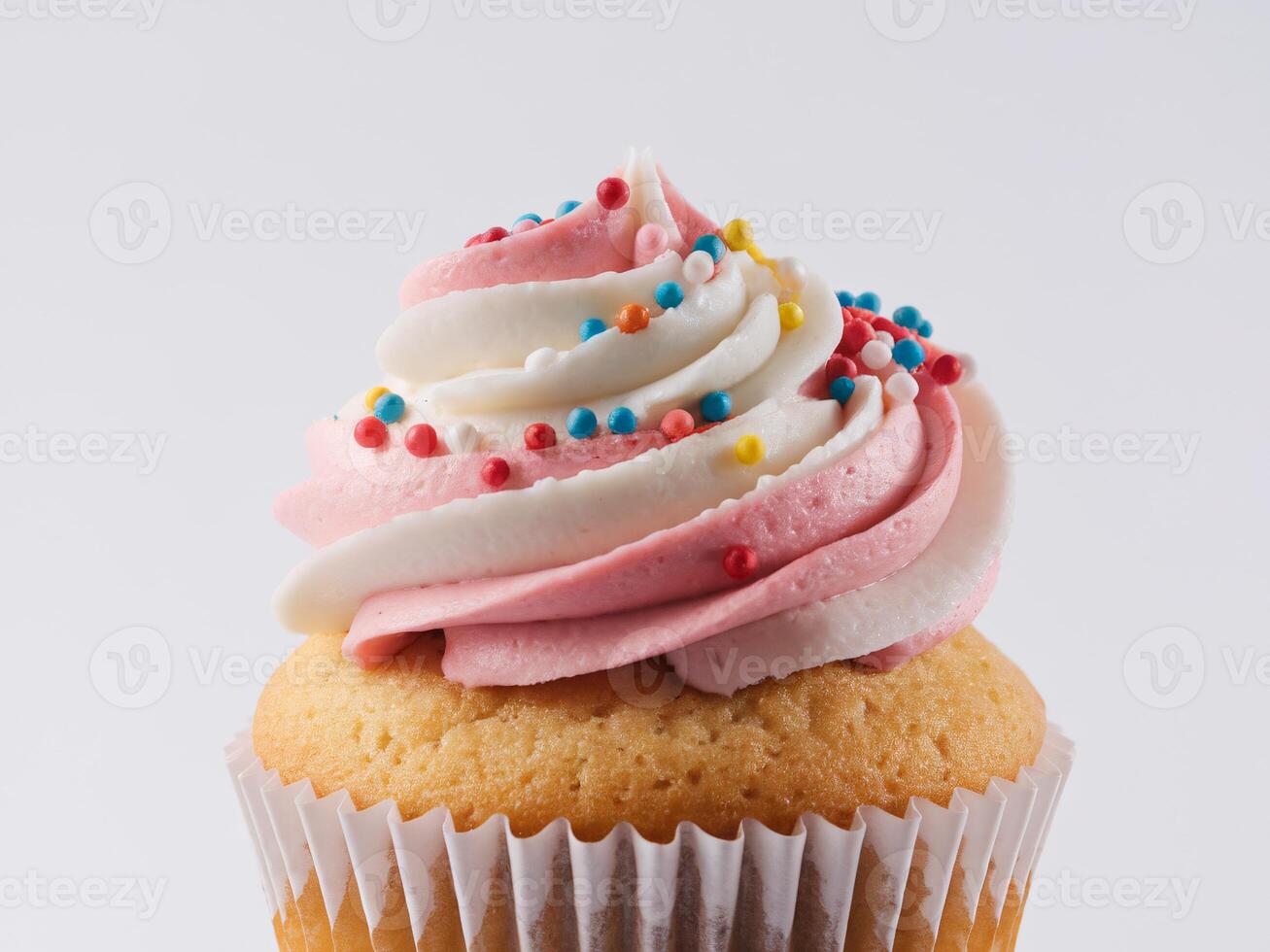Delicious cupcake topped with pink and white frosting and colorful sprinkles. photo