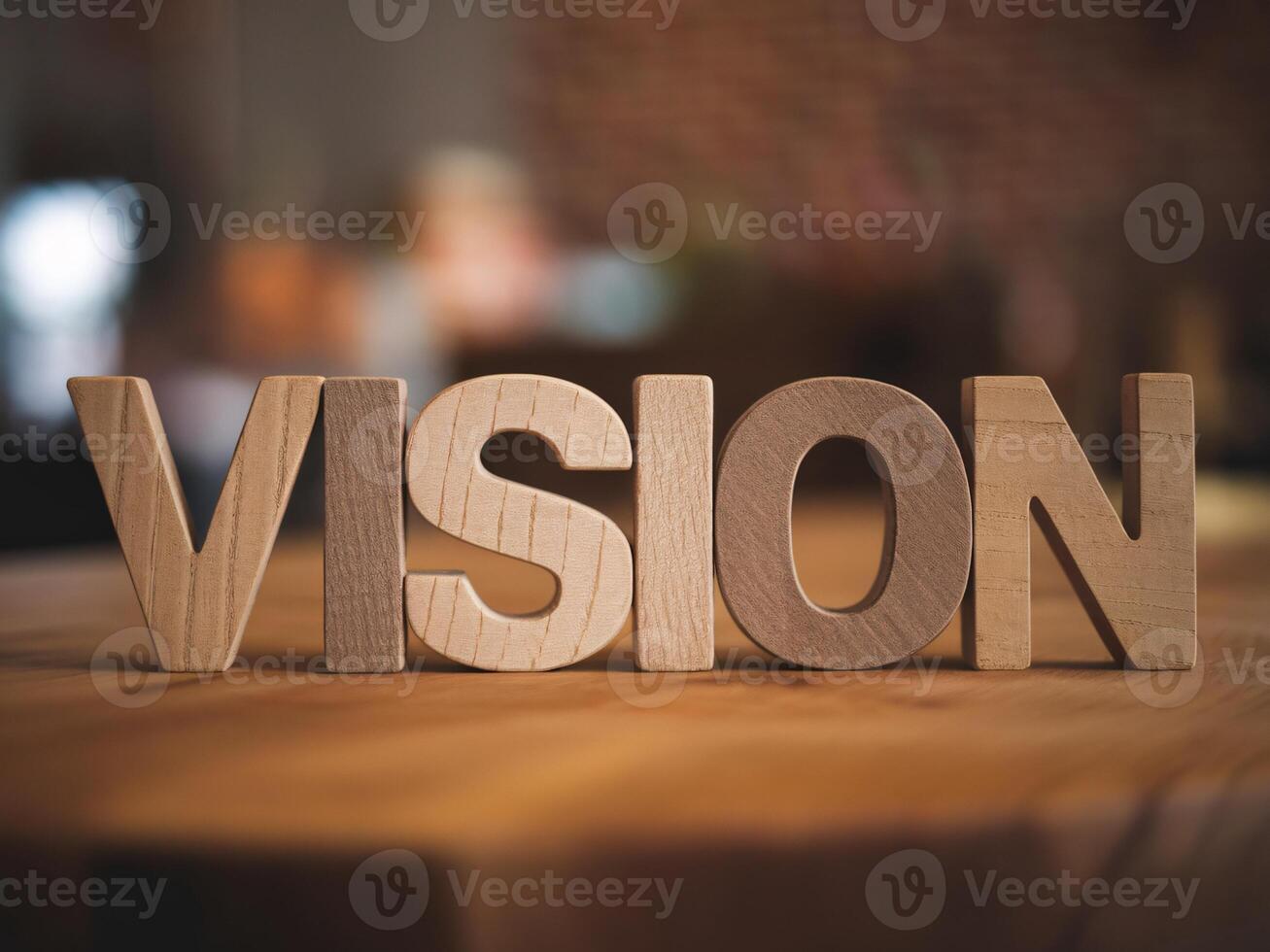 Stylish wooden letters forming the word 'VISION' on a rustic tabletop, evoking creativity and inspiration. photo