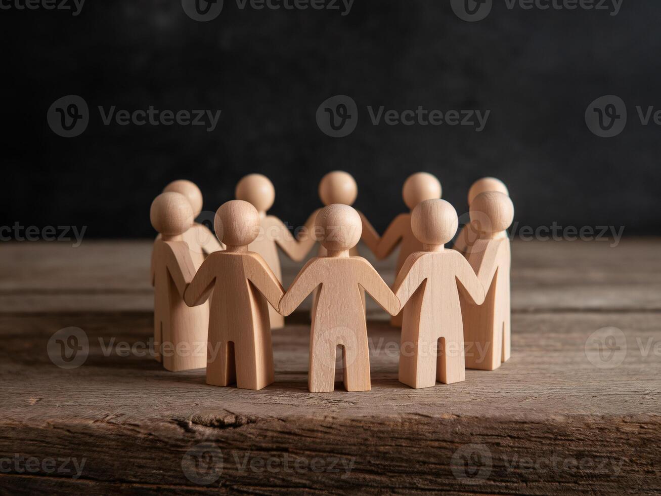 Wooden figures holding hands in a circle, symbolizing unity and community support. photo
