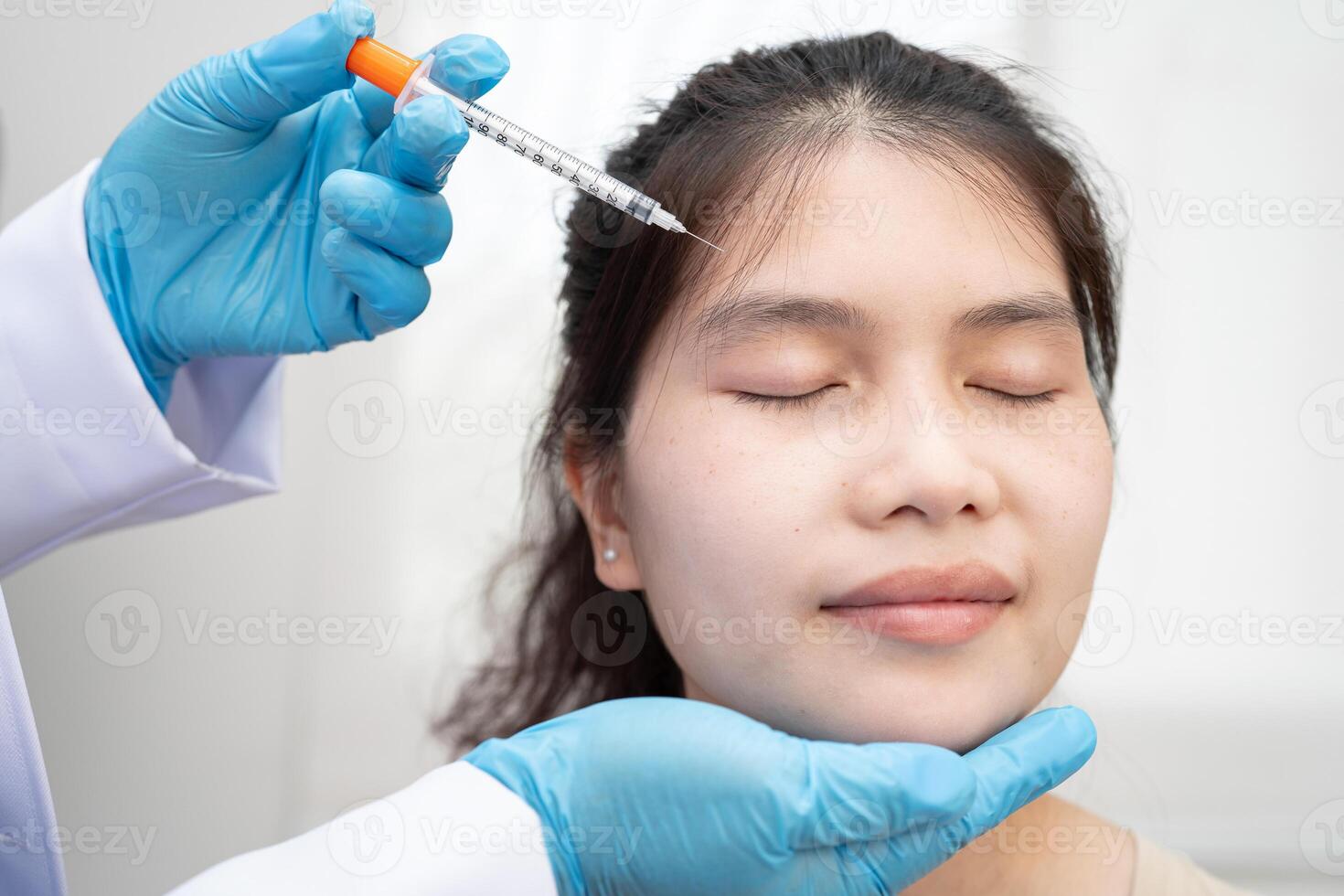 Asian woman receiving botox filler beauty injection. photo