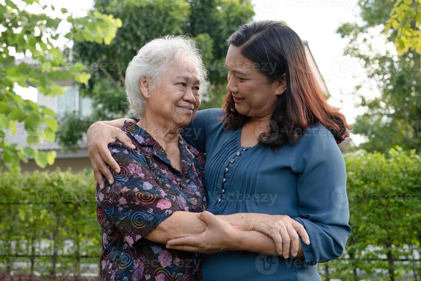 Asian elderly woman hug with her daughter with love, care, help, encourage and empathy at park, healthy photo