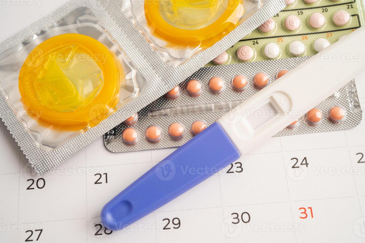 Pregnancy test and birth control pills on calendar, contraception photo