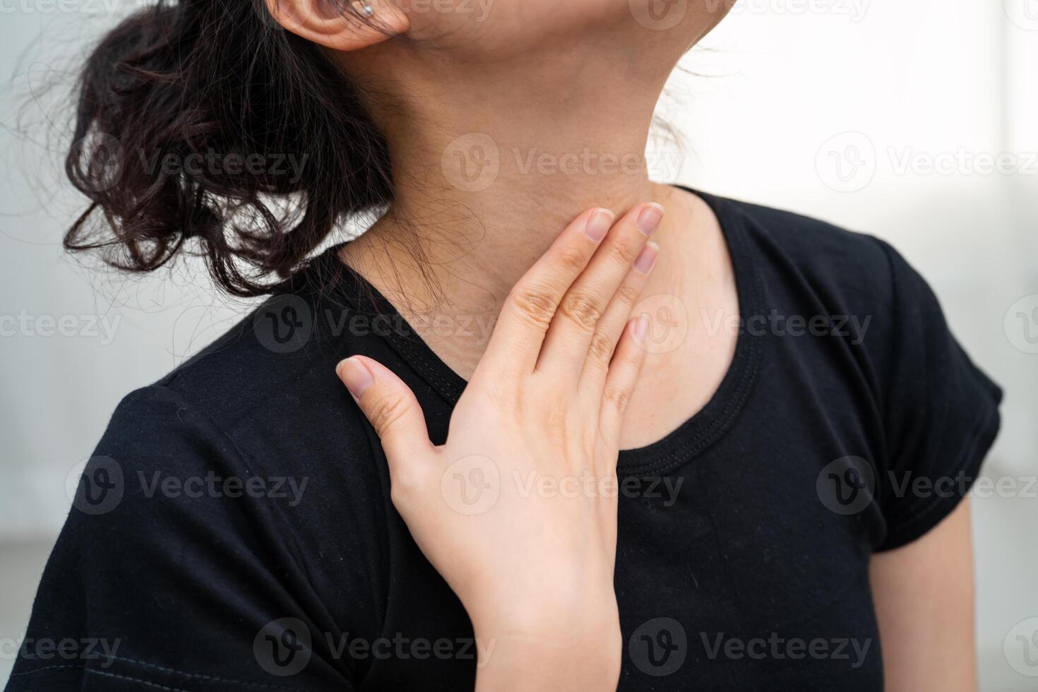 Asian woman touching her neck and throat for thyroid gland problem. photo