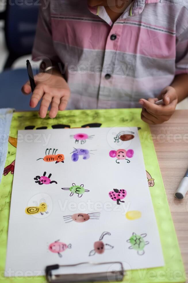 A child drawing on paper with a marker photo