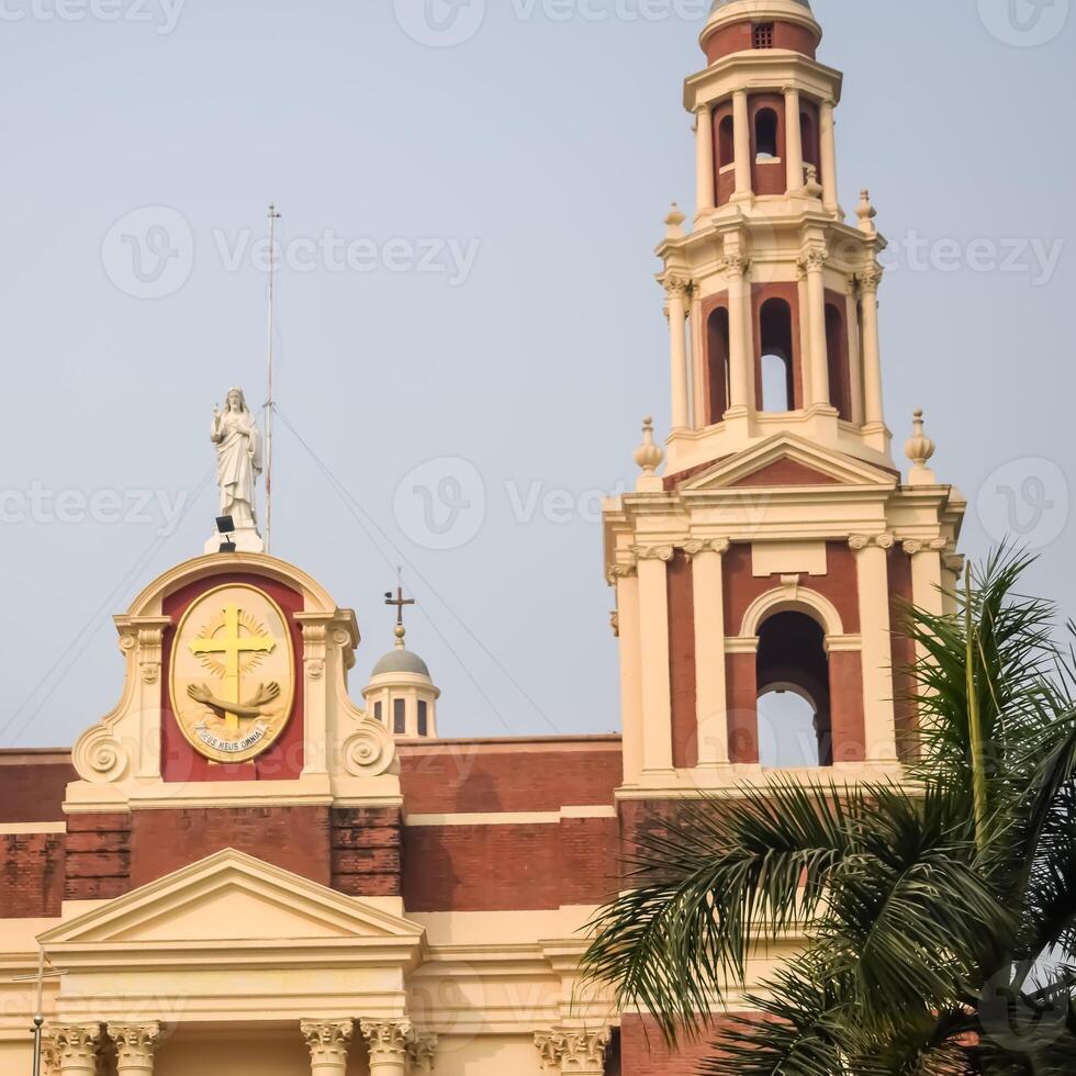 A large church with a clock tower and palm trees photo