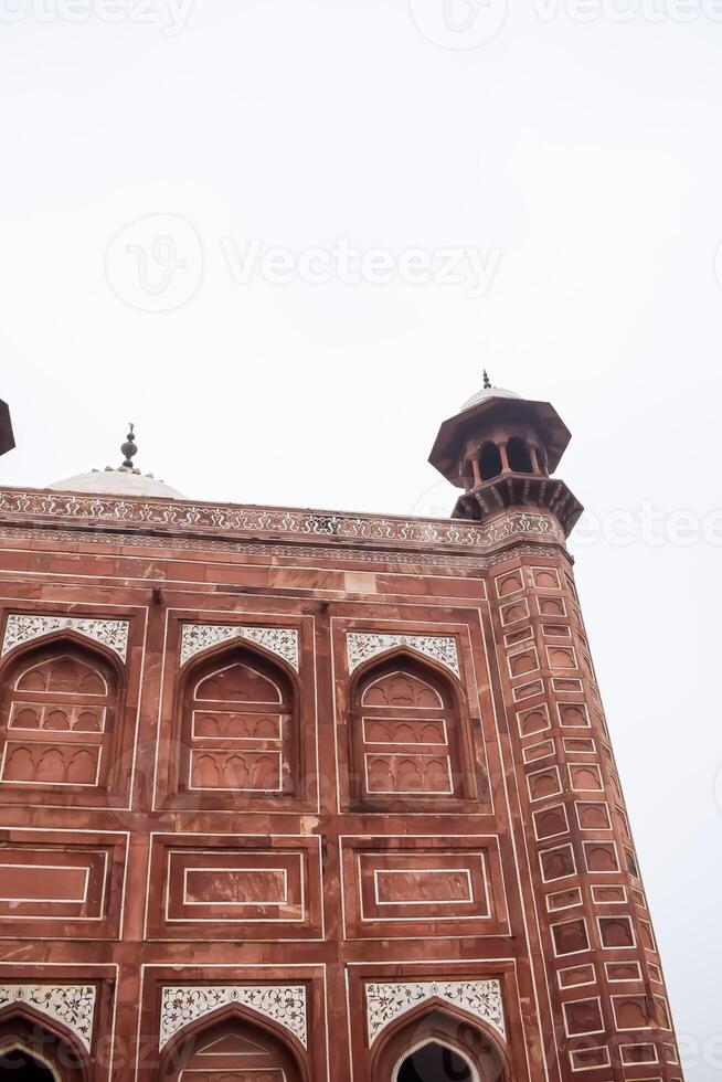 The taj mahal is a red brick building with two minarets photo