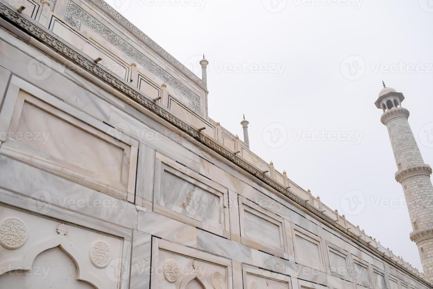The taj mahal is a white marble building with a tall minaret photo