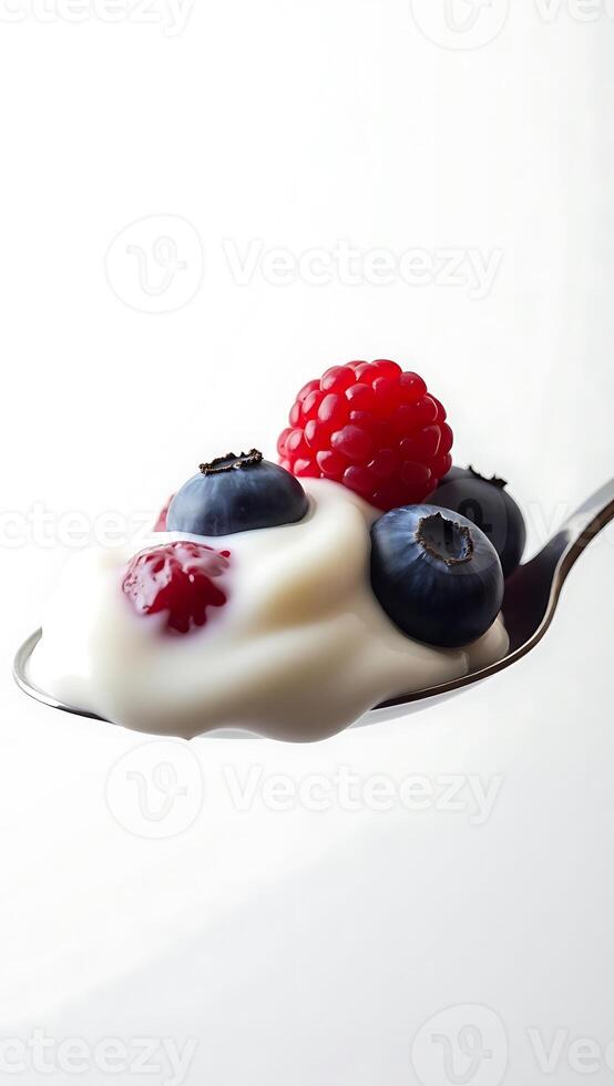 Closeup of a spoonful of yogurt topped with fresh blueberries and raspberries photo