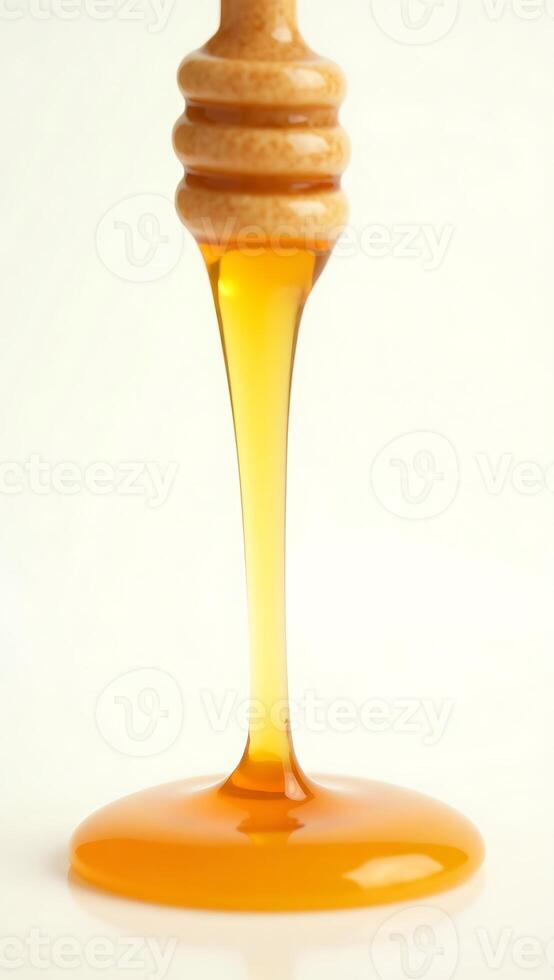 Closeup view of honey dripping from a wooden dipper on plain background photo