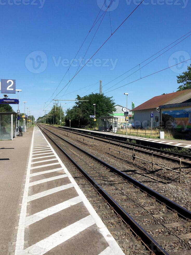 A railroad seen from a small train station. Two tracks. photo