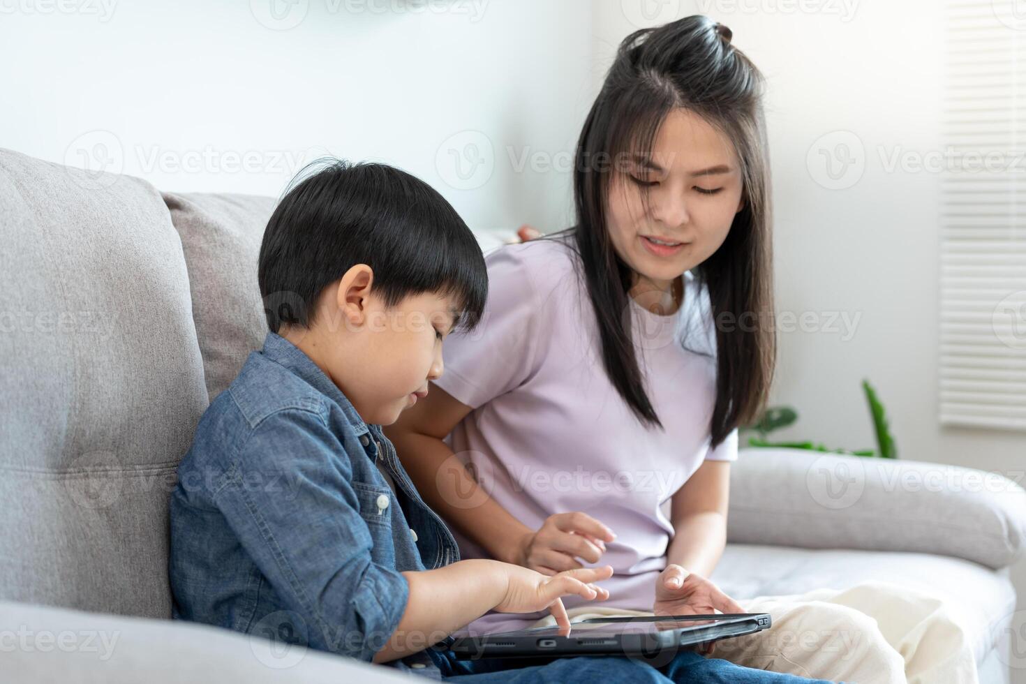 mother playing teach using tablet with the little boy. family is happy and excited in the house. mother and son having spending time together, Good daddy , addiction fix, handle, control photo