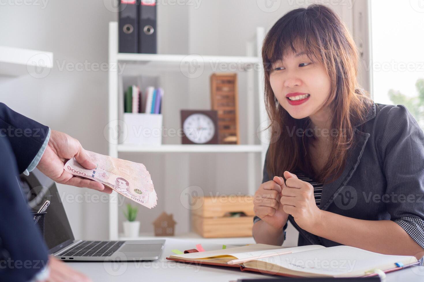 receive salary or bonuses from management or Boss. Company give rewards to encourage work. Smiling businessman enjoying a reward at the desk in the office photo