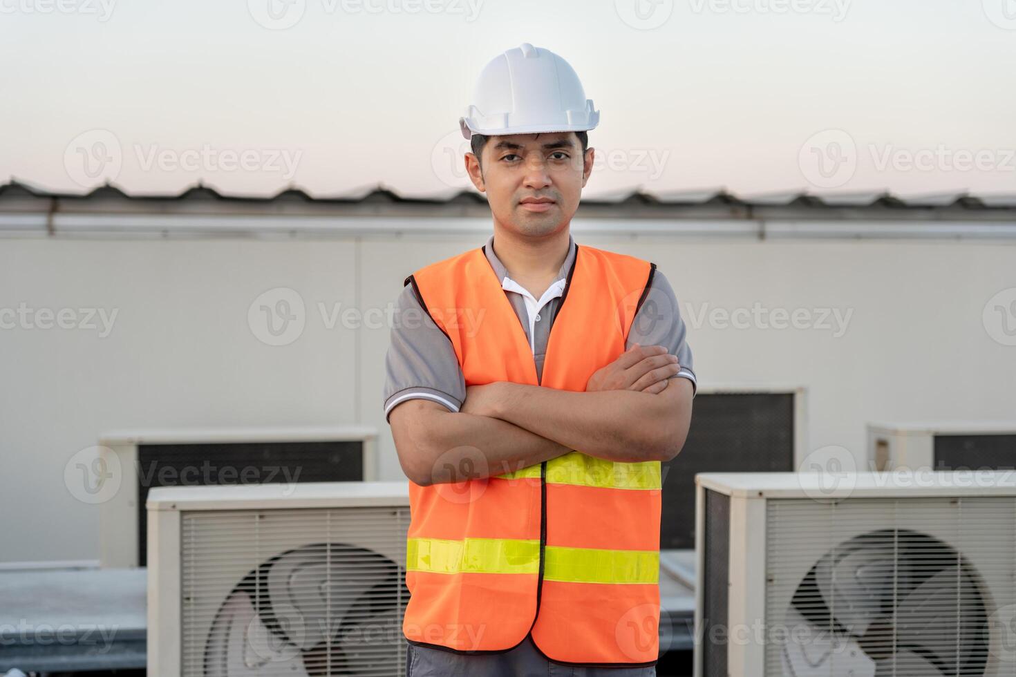 Portrait Asian maintenance engineer works on the roof of factory. contractor inspect compressor system and plans installation of air condition systems in construction, inspector, control. photo