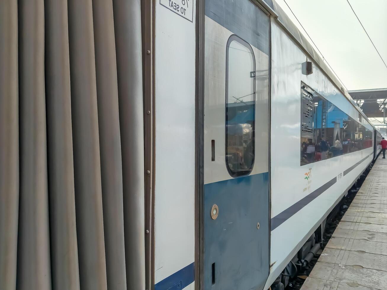 A train is parked at a station with people standing around photo