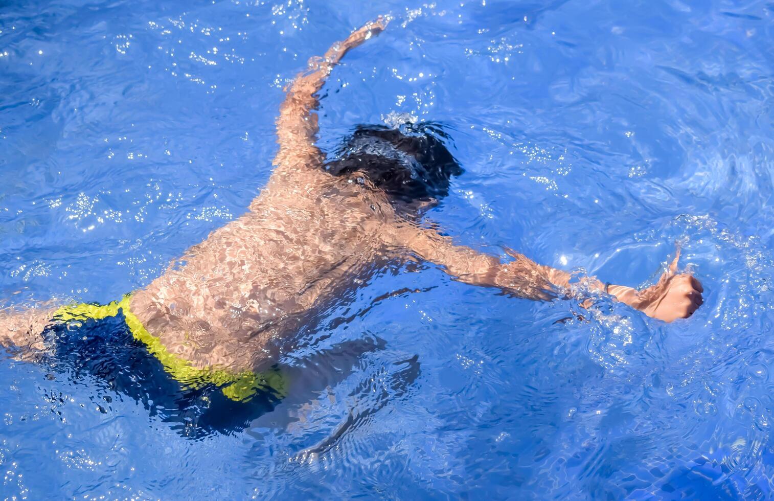 A boy in a blue swimming pool photo