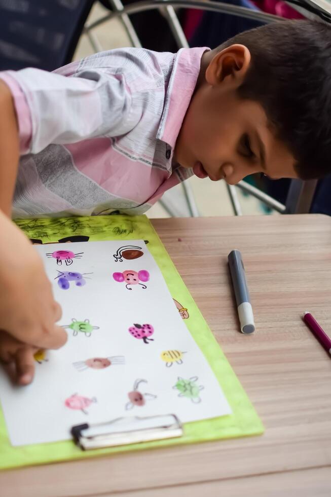 A child is drawing on a piece of paper photo