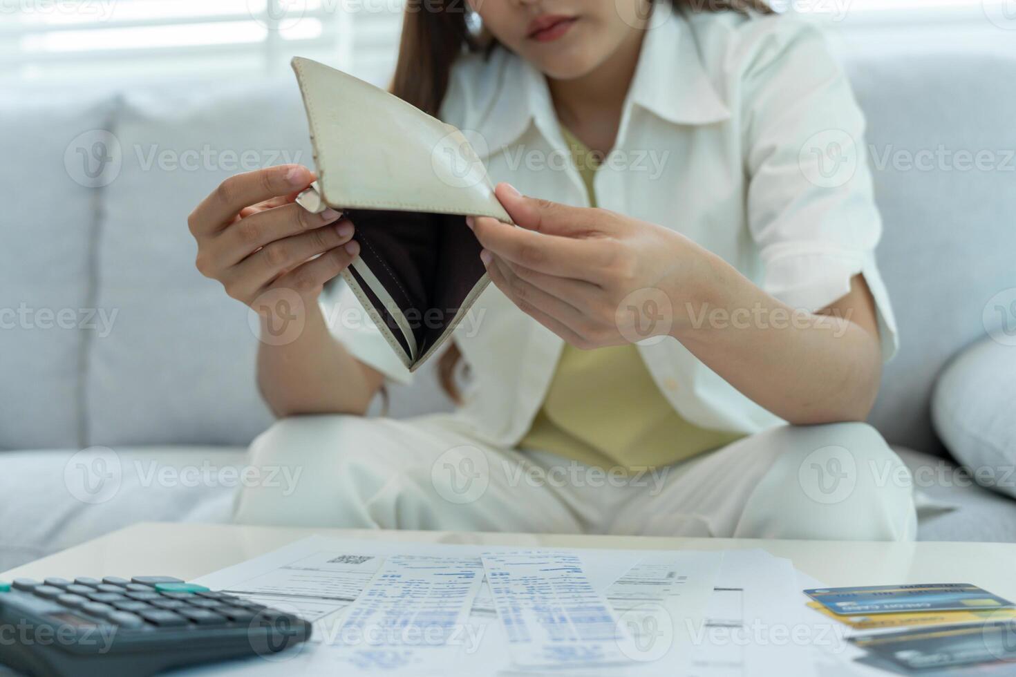 Stressed and headache asian woman with large bills or invoices no money to pay to expenses and credit card debt. shortage, Financial problems, mortgage, loan, bankruptcy, bankrupt, poor, empty wa photo