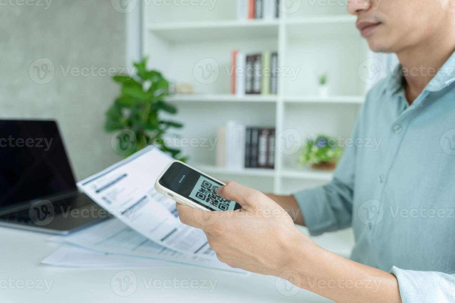 man use phone to scan barcode or QR codes to pay credit card bill after receiving document invoice online. payment, receive, paying electricity, digital payments without money, technology. photo