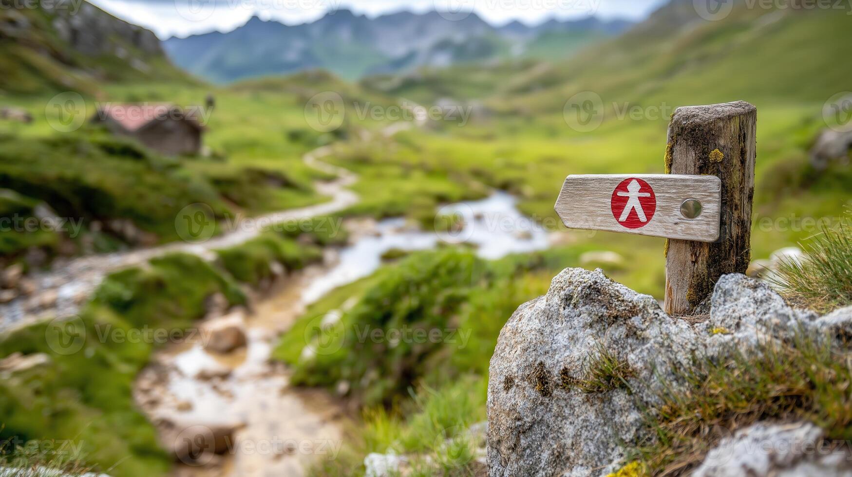 A wooden sign pointing to a trail in the mountains photo