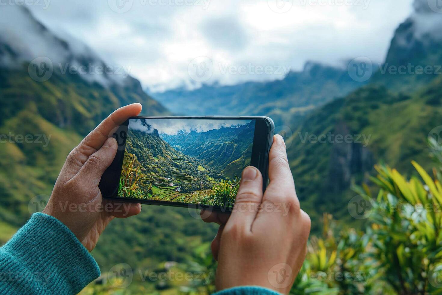 A tourist takes a photo of a hilltop rice field landscape with his smartphone. The man's hands hold the smartphone to take a photo. Travel concept.