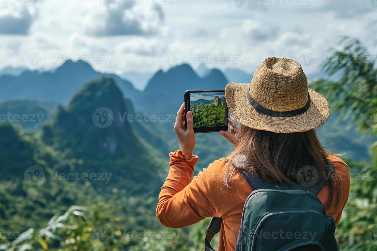 A female tourist takes a photo of nature on a tablet in the mountains in summer. A female tourist during her vacation.