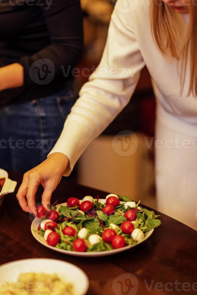 Close-up of a salad plate with mozzarella and herbs. Fresh cherry tomatoes, cheese and spinach leaves photo