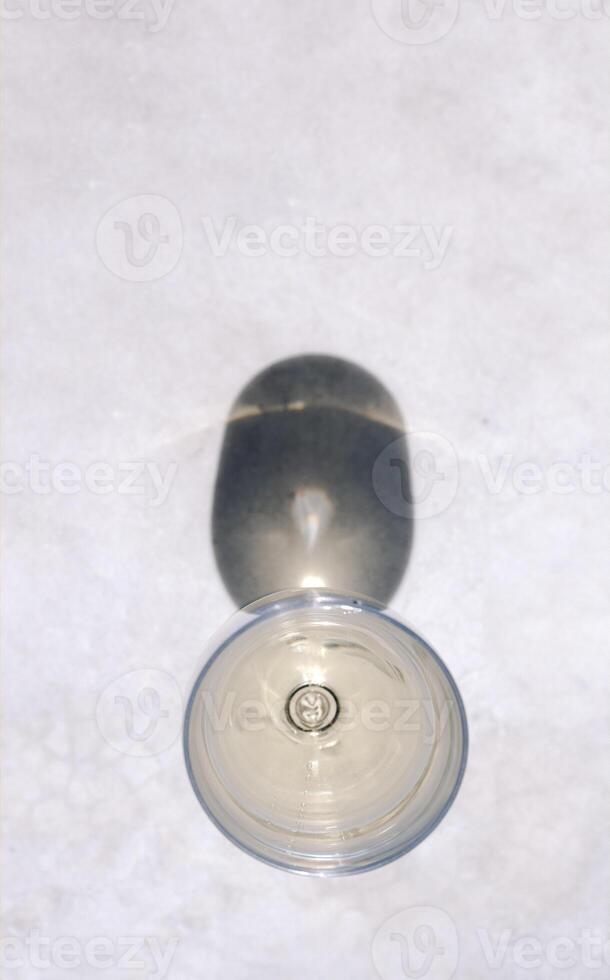 Two elegant long-stemmed glass with chilled alcoholic beverages on a marble table photo