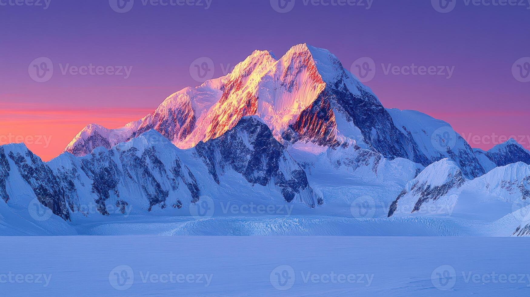A mountain range with snow covered peaks at sunset photo