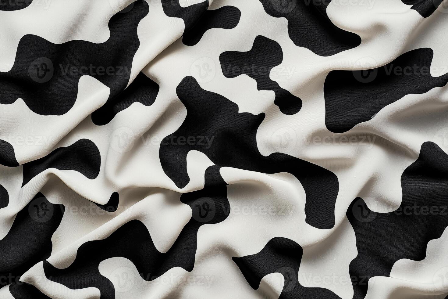 Black and White Cow Print Fabric with Soft Wrinkles and Smooth Texture Close-Up photo