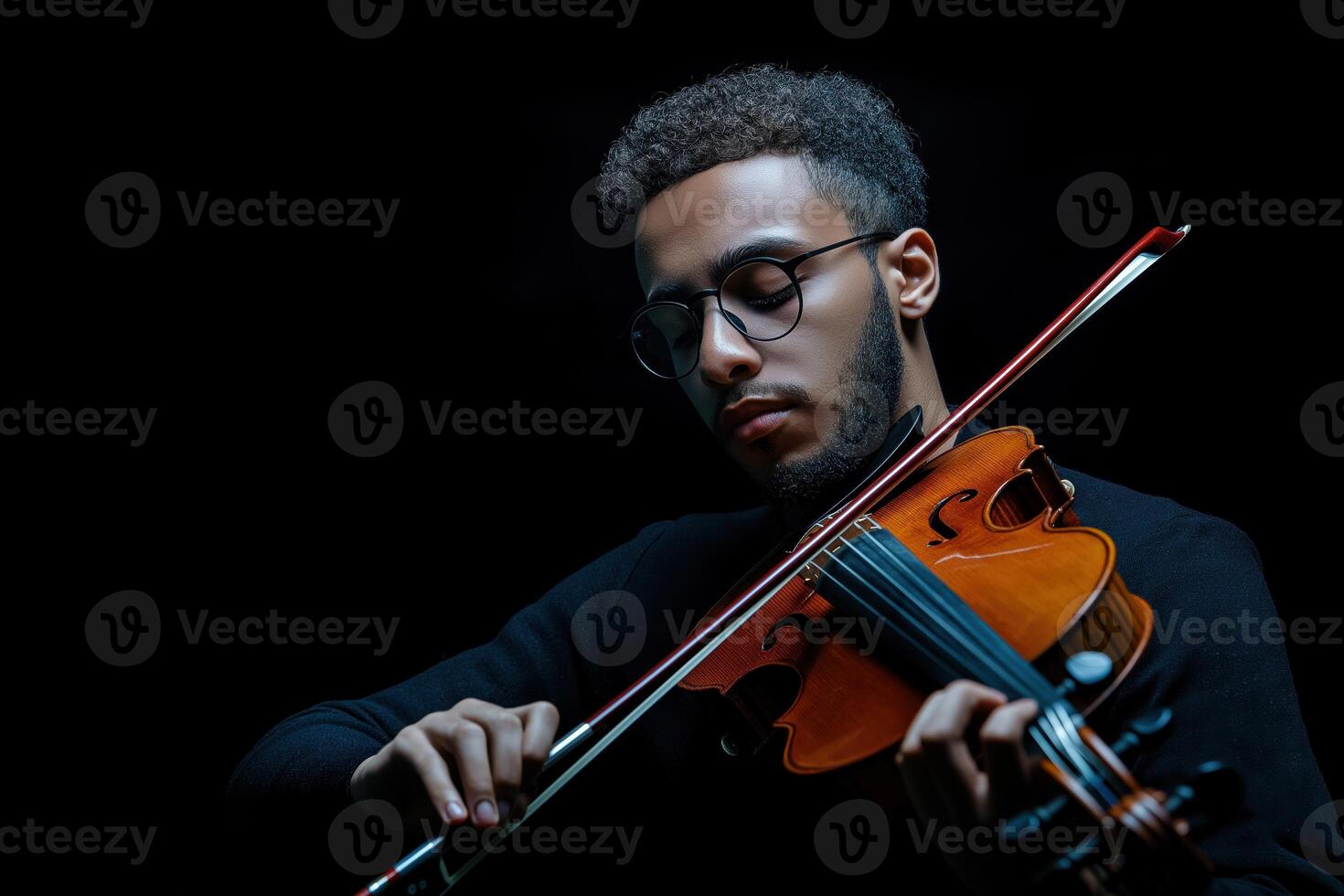 Portrait of a violinist playing music in dramatic lighting with a dark background photo