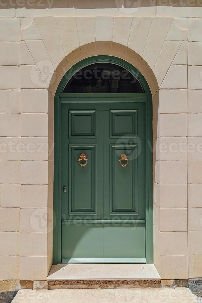 Elegant entrance crowned by subtle arch emphasizes local heritage, entrance capturing graceful lines of woodwork, entrance uniting old charm and modern city living in Maltese context photo