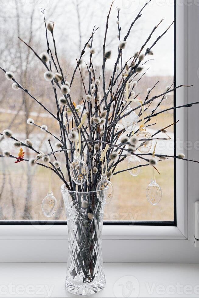 Willow Branches in Crystal Vase on Windowsill with Soft Natural Background photo
