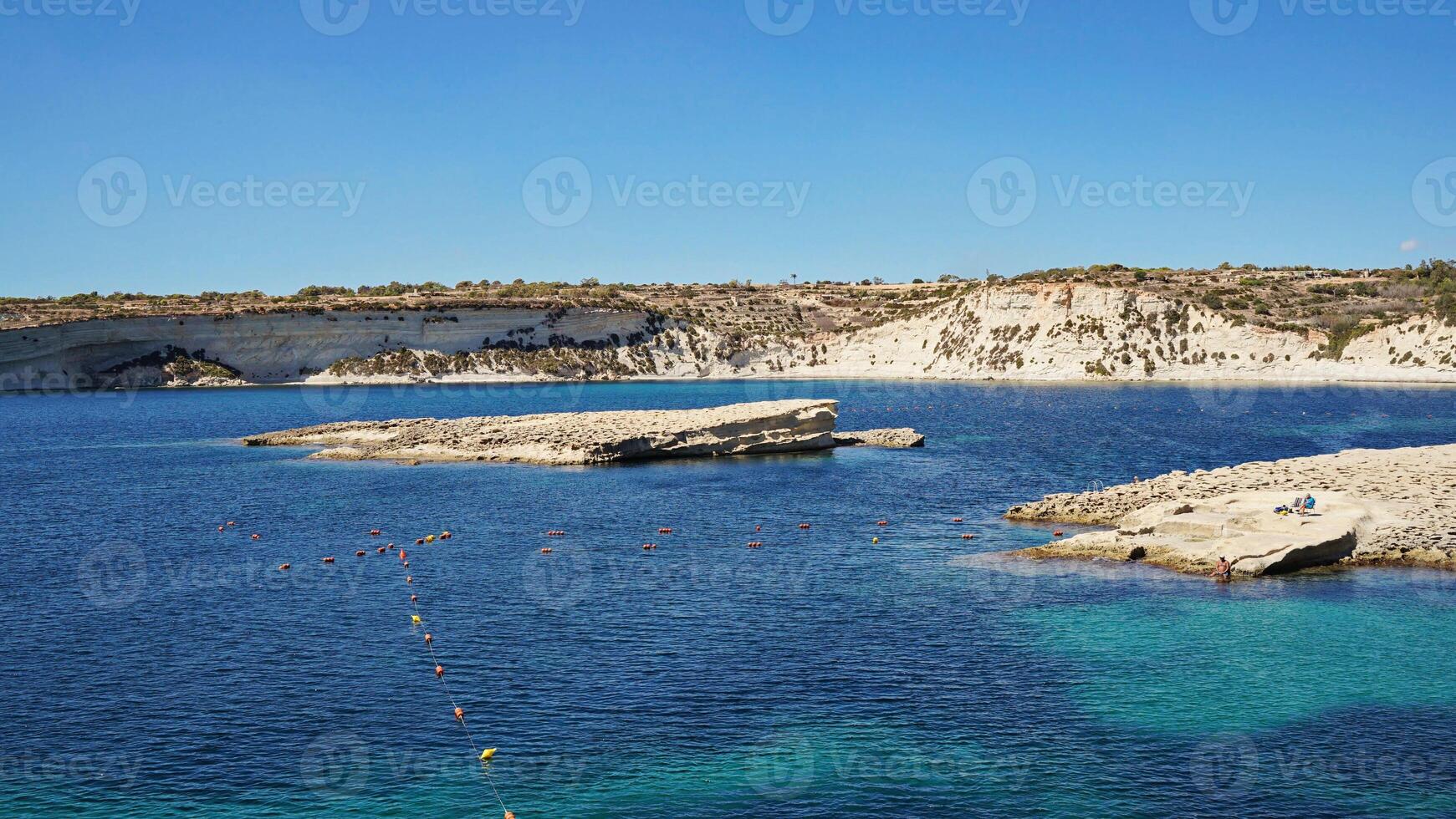 Malta coastline glimmers with azure sea, malta environment merging rocky shores photo