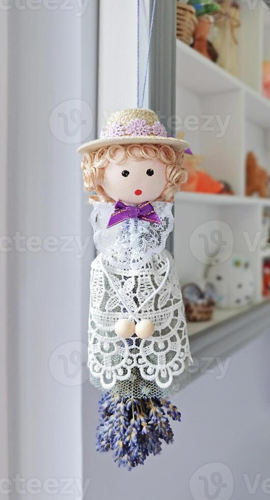 Whimsical doll suspended with lavender bunch channels romantic aura, romantic vibe photo