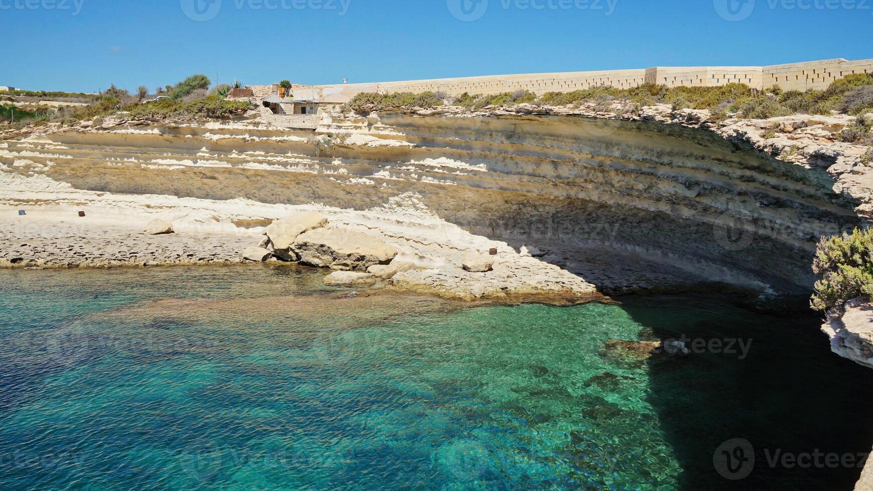 Limestone Cliffs and Clear Turquoise Waters on the Maltese Coast photo