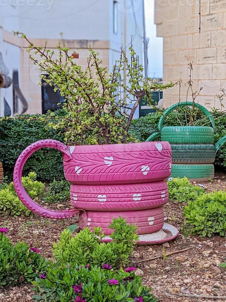 Vibrant tire planters brighten outdoor space with playful expressions, blending sustainability with creative garden decor photo
